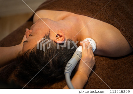 A man receiving facial treatment using cavitation at a men's beauty salon (skin care) 113316299