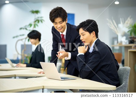 A young businessman in a suit working in the office A young businessman in a suit working in the office 113316517