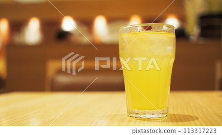 a glass of ice tea on vintage wooden table on the background of Blurred interior of luxury restaurant panoramic background. 113317223