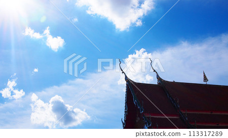 Blue sky and white clouds with sun beam over the buddhist temple roof in Thailand. Picture for use in Background image or copy space Blue sky and white clouds with sun beam over the buddhist temple roof in Thailand. Picture for use in Background image or copy space 113317289