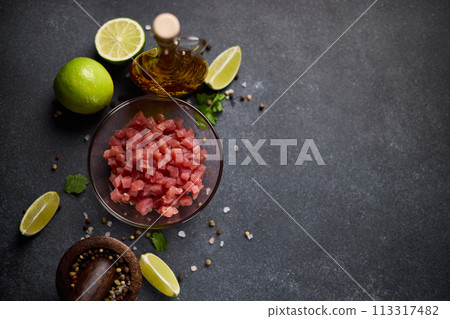 Sliced and chopped tuna fillet in glass bowl at domestic kitchen cooking traditional tartare Sliced and chopped tuna fillet in glass bowl at domestic kitchen cooking traditional tartare 113317482