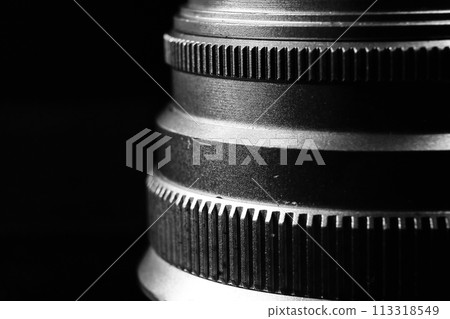 The image is a black and white close-up of a camera lens. The image is a black and white close-up of a camera lens. 113318549