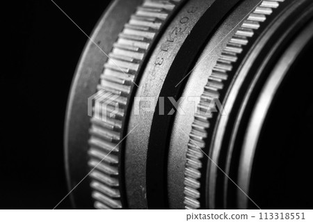 The image is a black and white close-up of a camera lens. The image is a black and white close-up of a camera lens. 113318551