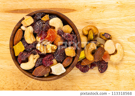 Top view of various dried mixed fruits and nuts in wooden bowl. Top view of various dried mixed fruits and nuts in wooden bowl. 113318568