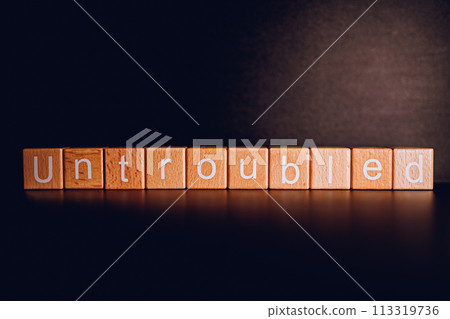 Wooden blocks form the text "Untroubled" against a black background. 113319736