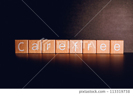 Wooden blocks form the text "Carefree" against a black background. 113319738