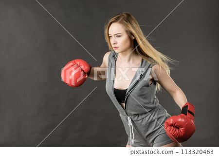 Woman wearing boxing gloves 113320463