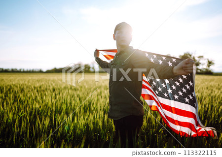 Man hold waving american USA flag. Patriot raise national american flag. Independence Day, 4th July. 113322115