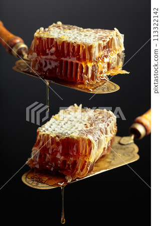 Honeycombs on an antique brass spatula. Honeycombs on an antique brass spatula. 113322142