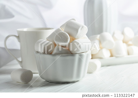 White marshmallows on a wooden table. White marshmallows on a wooden table. 113322147