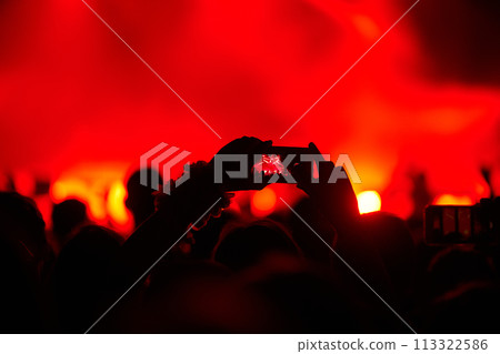 Hand with a phone records live music festival. People taking photographs with smart phone during concert. Hand with a phone records live music festival. People taking photographs with smart phone during concert. 113322586