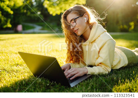 Smiling young woman with laptop working on background of city building. Education, freelance concept Smiling young woman with laptop working on background of city building. Education, freelance concept 113323541