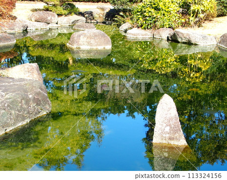 日本花園中的池塘反射著冬天的藍色天空 日本花園中的池塘反射著冬天的藍色天空 113324156