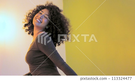 Latin woman dancing with sensual movements in a party Latin woman dancing with sensual movements in a party 113324477