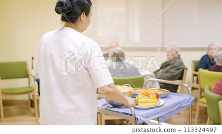 Cook entering with food to the dining room of geriatric Cook entering with food to the dining room of geriatric 113324497