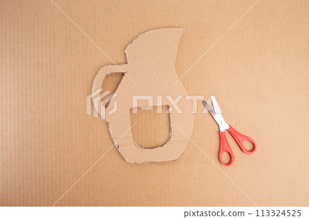 a paper cut out of a pitcher next to a pair of scissors, cut out of cardboard, assemble, 113324525