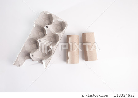 Egg carton box and empty toilet paper roll, minimalist composition, disassembled, top view on white background. 113324652