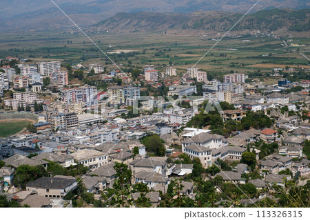 Girokastra is a city in southern Albania, in valley of Drinos River. Administrative center of region and municipality. Mediterranean climate. Cityscape with those famous aligned white facades. 113326315