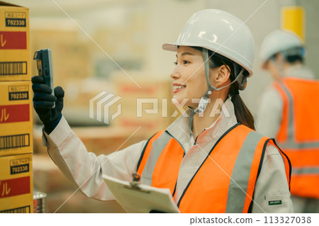 A young female worker checking inventory on a terminal 113327038
