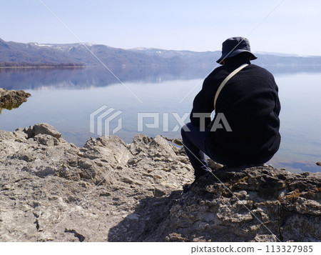 A man looking at a beautiful lake (back view) A man looking at a beautiful lake (back view) 113327985