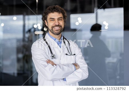 A welcoming Hispanic male doctor with a confident smile, standing in a modern hospital or clinic environment, exuding professionalism and warmth. 113328792