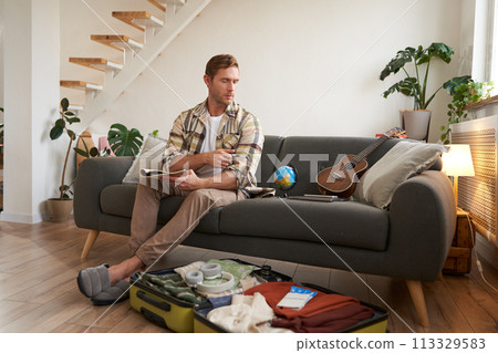 Portrait of traveller preparing for another journey, tourist packs suitcase with clothes for holiday, going on vacation 113329583