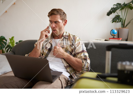 Portrait of angry man, looking frustrated, talking on mobile phone, sitting with laptop and suitcase Portrait of angry man, looking frustrated, talking on mobile phone, sitting with laptop and suitcase 113329623