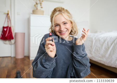 Portrait of cute, charismatic beauty blogger, woman sits in a room with lipstick in hand, talking about makeup, chatting with followers, recording online stream on social media app Portrait of cute, charismatic beauty blogger, woman sits in a room with lipstick in hand, talking about makeup, chatting with followers, recording online stream on social media app 113330639