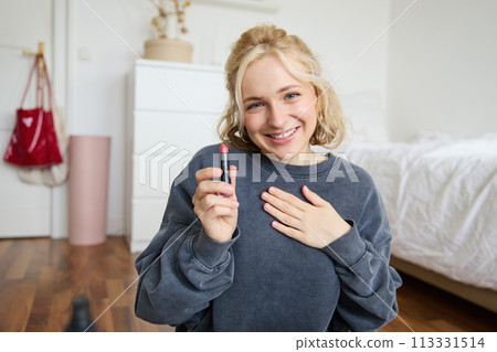 Portrait of young beautiful woman, content maker creating a new vlog, beauty video, showing lipstick, recommending makeup, records a tutorial Portrait of young beautiful woman, content maker creating a new vlog, beauty video, showing lipstick, recommending makeup, records a tutorial 113331514