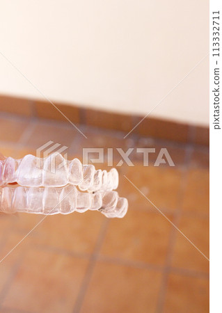 Invisible teeth aligner on light background Invisible teeth aligner on light background 113332711