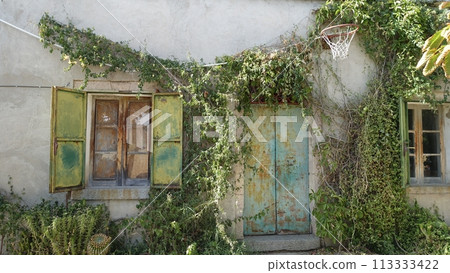 The facade of an old country house with an old basketball hoop on the wall The facade of an old country house with an old basketball hoop on the wall 113333422