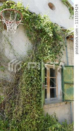 The glimpse of an old country house with an old basketball hoop on the wall The glimpse of an old country house with an old basketball hoop on the wall 113333424