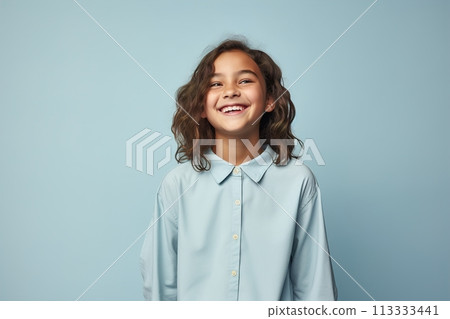 A young girl with long hair is smiling and wearing a blue shirt 113333441