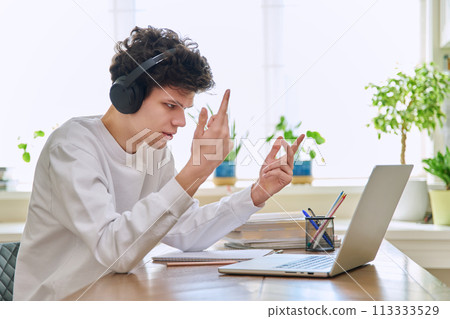 Guy student in headphones looking at web cam computer, talking studying online Guy student in headphones looking at web cam computer, talking studying online 113333529