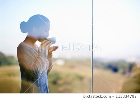 Woman, coffee with window and balcony outdoor, drink warm beverage with morning routine and zen in nature. Peace, calm and espresso for caffeine, glass and tea cup in countryside for leisure Woman, coffee with window and balcony outdoor, drink warm beverage with morning routine and zen in nature. Peace, calm and espresso for caffeine, glass and tea cup in countryside for leisure 113334792