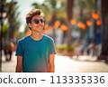 A young man wearing a blue shirt and sunglasses is smiling 113335336
