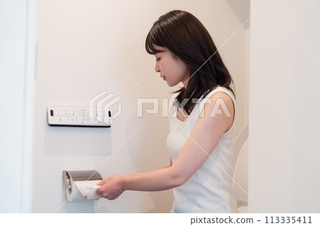 Young woman pulling toilet paper Young woman pulling toilet paper 113335411