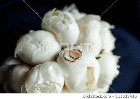 Bride's bouquet of white peonies with wedding rings Bride's bouquet of white peonies with wedding rings 113335430