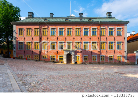 The facade of Stenbock Palace is bathed in sunlight, accentuating its striking pink exterior and ornate windows, set against a cobblestone square in Stockholm. The facade of Stenbock Palace is bathed in sunlight, accentuating its striking pink exterior and ornate windows, set against a cobblestone square in Stockholm. 113335753