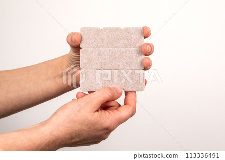 Furniture Protection Felt in Hands on a hite background Furniture Protection Felt in Hands on a hite background 113336491