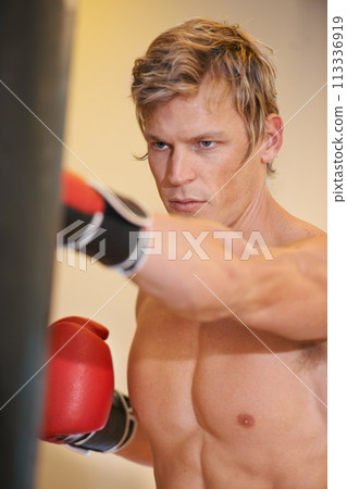 Man, exercise and boxing with punching bag in gym with vision, power and training for fight, wellness and health. Contact sports, athlete and person in gloves, fist or action in martial arts workout Man, exercise and boxing with punching bag in gym with vision, power and training for fight, wellness and health. Contact sports, athlete and person in gloves, fist or action in martial arts workout 113336919