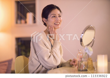 Middle-aged woman doing night skin care Middle-aged woman doing night skin care 113336922