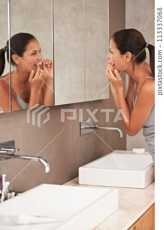 Mirror, bathroom and woman with floss for cleaning, oral hygiene and dental care in home. Morning routine, healthcare and person for whitening, wellness and grooming for gum disease and fresh breath 113337068