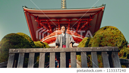 Man, Japanese shinto temple and traditional clothes for culture, building or religion in sunshine. Person, ideas and vision for perspective with faith, mindfulness or thinking with low angle in Kyoto 113337240