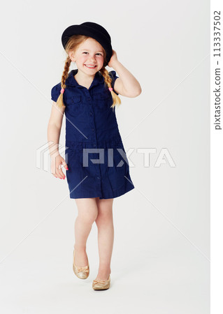 Portrait, smile and fashion with girl child in studio on white background for casual kids style. Children, dress and hat with happy or confident little youth in cute and adorable blue clothes outfit 113337502