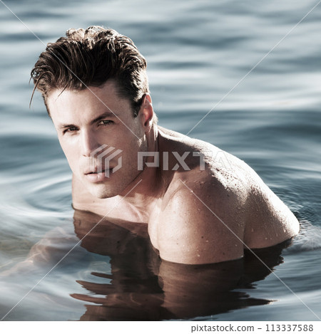 Young man, swimming and portrait in ocean, water or pool for health, wellness and fitness. Face of a person, swimmer or model with outdoor training, physical activity or workout for body or exercise 113337588