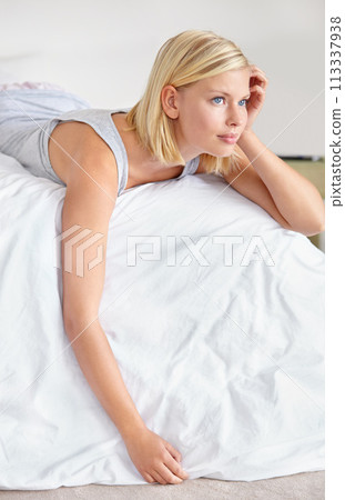 Relax, thinking and woman in bedroom of hotel on weekend for luxury hospitality or accommodation. Home, vision and morning wake up with cozy young blonde person lying on bed of guest house apartment 113337938