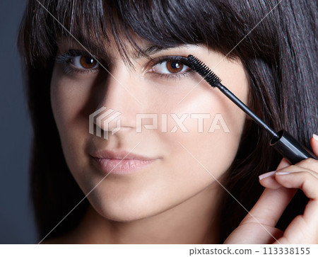 Beauty, skincare and portrait of woman with mascara for natural makeup, facial and studio. Lashes, application and cosmetics with face of girl isolated on blue background with brush, tools and pride. Beauty, skincare and portrait of woman with mascara for natural makeup, facial and studio. Lashes, application and cosmetics with face of girl isolated on blue background with brush, tools and pride. 113338155