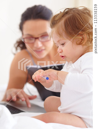 Mom, working and multitasking on laptop with baby in home for remote work or writing project. Infant, kid and mother busy with freelance productivity on computer and child in bedroom playing with pen 113338159