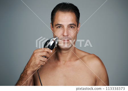 Man, portrait and shave with electric razor for beard hair removal grooming or maintenance, hygiene or grey background. Male person, face and tool for healthy self care in studio, mockup or skincare 113338373